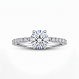 A silver-tone solitaire engagement ring with a round-cut clear center stone and a pavé-set diamond band, shown on a clean white background.